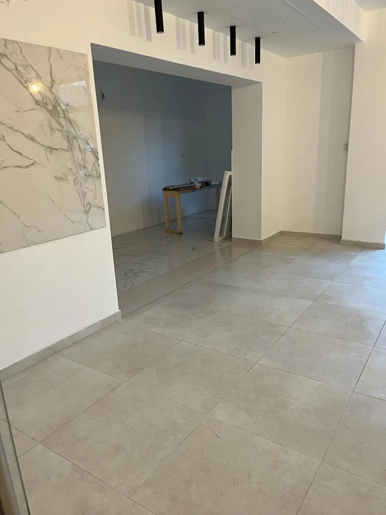 Spațiu de lucru cu pardoseală ceramică și perete din marmură, curat și pregătit.